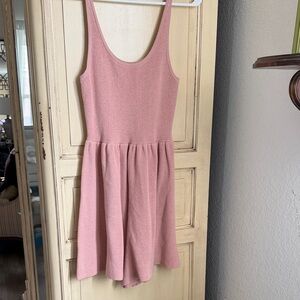 sleeveless pink knit romper with a ribbed bodice and flared shorts.
